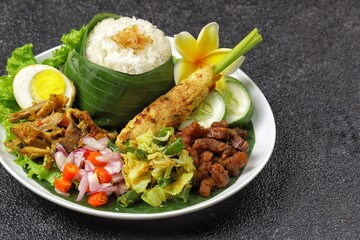 Nasi Campur Bali is a traditional Balinese dish consisting of warm white rice and various side dishes in small portions, such as shredded chicken, sate lilit, lawar, and sambal matah.