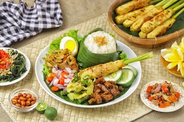 Nasi Campur Bali is a traditional Balinese dish consisting of warm white rice and various side dishes in small portions, such as shredded chicken, sate lilit, lawar, and sambal matah.