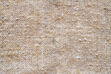 The texture of coarse burlap fabric. Natural brown fabric with coarse fibers
