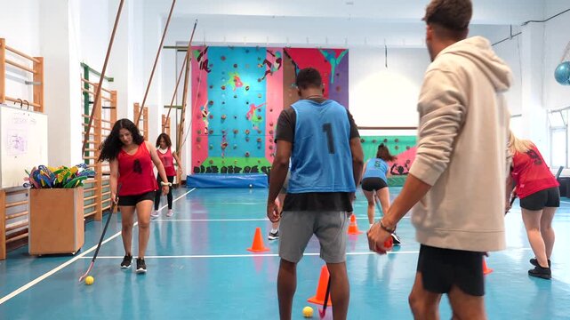 Young athletes playing floorball in gym