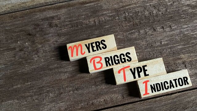 A conceptual diagram shows the words Myers Briggs Type Indicator on separate wooden blocks. The blocks are arranged to highlight the acronym MBTI.
