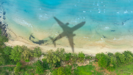 Aerial view of shadow passenger plane silhouette and sandy beach blue sea with waves at sea beach summer vacation sea travel concept	
