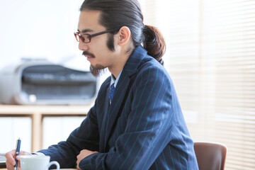 デスクワークをする眼鏡をかけたビジネスマン