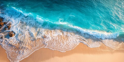 Fototapeta premium Aerial View of Serene Beach with Soft Waves, Golden Sand and Clear Blue Water Under Bright Sunny Sky