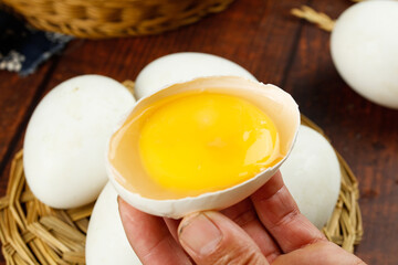 Fresh Farm Eggs in Basket with Cracked Shell Showing Golden Yolk