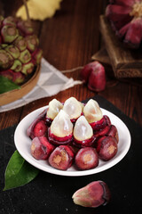 Fresh Water Chestnuts with Red Skin and White Pulp on Rustic Wooden Table - Tropical Asian Fruit