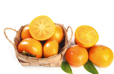 Fresh Orange Persimmons in Wicker Basket on White Background with Cut Fruit Showing Star Pattern