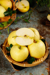 Fresh Yellow Apples in Wicker Basket with Sliced Apple Showing Crisp White Flesh and Natural Harvest Display