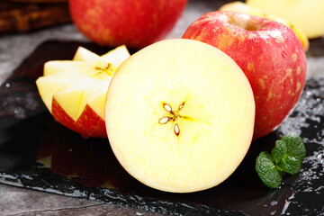 Fresh Red Apples Sliced on Dark Slate with Water Droplets and Mint Leaves