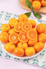 Fresh Small Guangxi Tangerines on White Plate with Green Leaves - Sweet Citrus Fruit Display