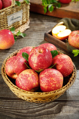 Fresh Red Fuji Apples in Wicker Basket on Rustic Wood Table