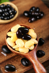 Mixed Black and Yellow Beans Seeds in Wooden Spoon on Rustic Wood Background