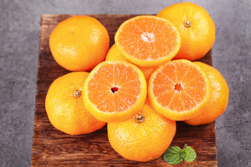 Fototapeta premium Fresh Guangxi Tangerines on Wooden Board - Sweet Chinese Citrus Fruit