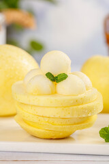 Fresh Yellow Apple Slices with Ice Cream Dessert and Mint Garnish on Marble Surface
