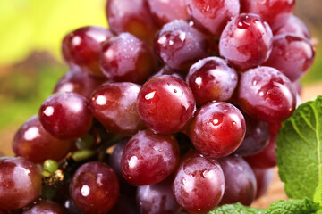 Fresh Red Grapes with Water Droplets and Green Leaves Close-up