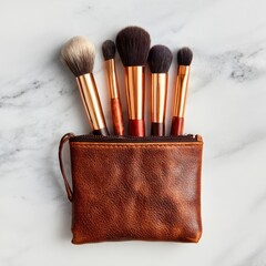 Elegant leather makeup bag with makeup brushes organized above marble background for beauty and cosmetic application