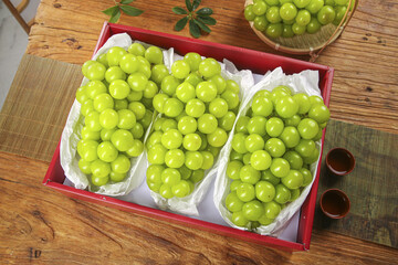 Fresh Green Grapes in Red Gift Box on Rustic Wood Table - Premium Fruit Arrangement