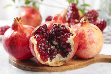 Fresh Pomegranate Fruits with Ruby Red Seeds and Soft White Pulp on Wooden Board