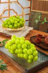 Fresh Green Grapes in Japanese Tea Setting with Bamboo Display and Traditional Ceramics