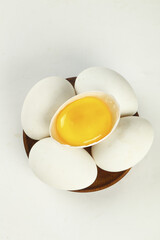 Fresh White Eggs in Wooden Bowl with Cracked Egg Showing Golden Yolk