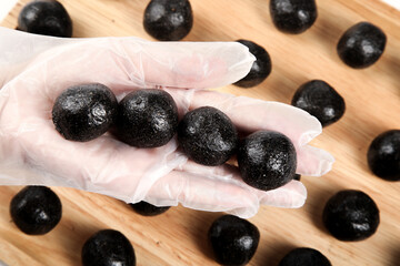 Handmade Honey Sesame Energy Balls in Hand - Healthy Nutrition Snack Closeup on Wood