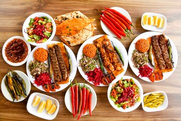 Delicious meat kebab with fresh vegetable salad served with variety of Turkish dishes and appetizers. Top view of assorted Turkish food and meze, tasty and healthy Mediterranean cuisine. Top view.