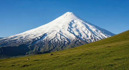 Stunning snow capped volcano mountain against clear blue sky in summer