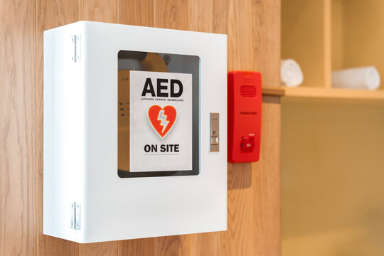 General view of a life saving defibrillator. Portable automated external defibrillator (AED) mounted on the wall in public restroom at airport.