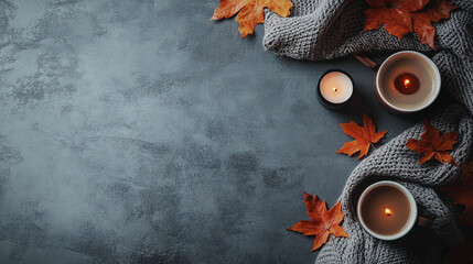 Cozy autumn scene with warm drinks candles and fall leaves on a textured background