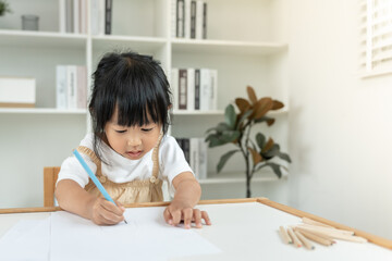 Naklejka premium Happy Asia child play and learn drawing picture and cartoon. Funny family is happy and excited in the house. Mother and daughter having fun spending time together. Holiday, Activity