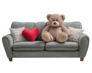 Teddy bear sitting on gray sofa with red heart pillow and decorative cushions, cozy and romantic atmosphere, soft lighting, plush toy, home interior