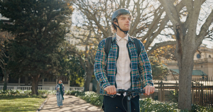 Man, student and riding on scooter outdoor for travel, eco friendly and trip to college. Male person, search and helmet safety with electric transport, sustainable commute and journey to university - Powered by Adobe