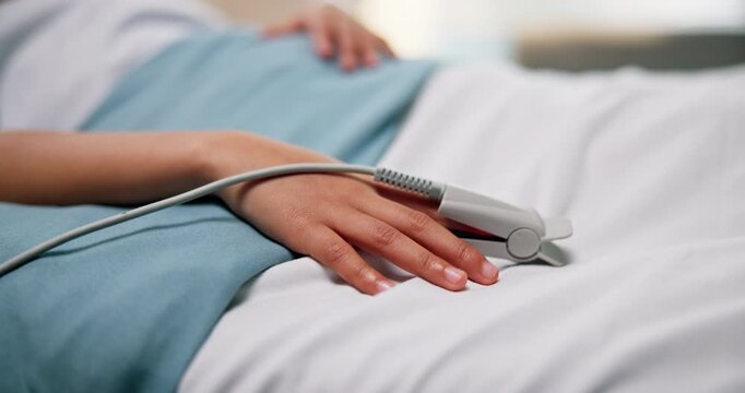 Hospital, child and hand with pulse oximeter, tech or measuring blood level of patient with illness. Healthcare, wellness and machine to monitor oxygen saturation, sickness and kid on bed in clinic