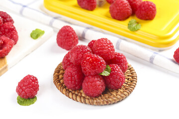 Fresh Red Raspberries in Wicker Basket with Mint on White Wood Background