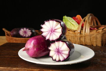 Fresh Purple Watermelon Radish Slices with Star Pattern and Vegetable Baskets on Wooden Table