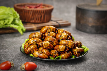 Traditional Asian Cicada Pupae Delicacy Served with Fresh Vegetables on Dark Plate