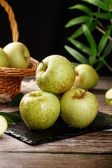 Fresh Green Apples from Shandong China on Rustic Wooden Table with Wicker Basket