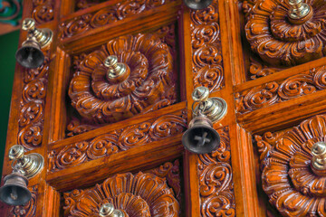 small bells in decorated wooden door - hindu temple