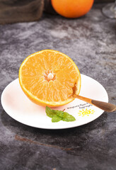 Fresh Sliced Orange Half with Mint on White Plate - Healthy Citrus Fruit Breakfast