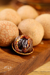 Yunnan Longan Fruit Close-up on Wooden Board - Exotic Asian Tropical Fruit with Shell and Seed Details