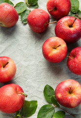 Fresh red apples forming a border on gray linen cloth