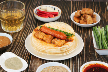 Zibo Barbecue Skewers with Wheat Pancakes and Traditional Chinese Sides on Wooden Table