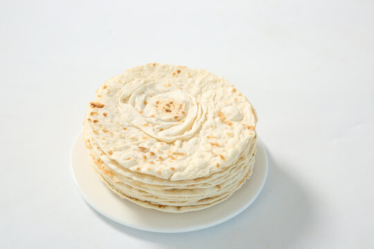 Zibo Style Thin Pancakes Rolled in Spiral on White Plate Isolated on White Background