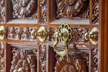 Decorated antique door knocker in hindu temple door	
