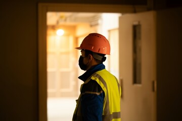 Construction worker wearing hard hat and mask in doorway