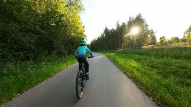 Boy riding the bicycle in the evening