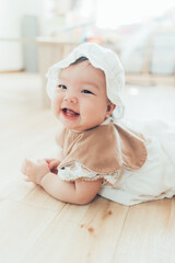 ボンネットをかぶるうつ伏せの赤ちゃん