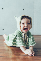 ボンネットをかぶるうつ伏せの赤ちゃん