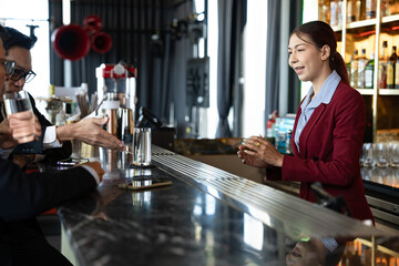 Attractive saleswoman, cashier serving customers at a retail store counter or bar restaurant counter.	