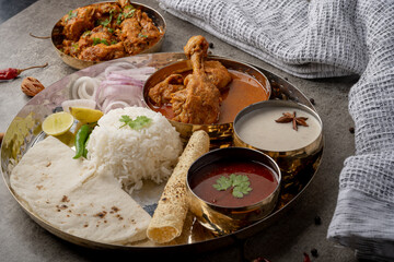 Kolhapuri chicken Thali is a popular Indian asian food platter consists of poultry meat, chikan sukka bhakri, rice, salad tambda padhra rassa 